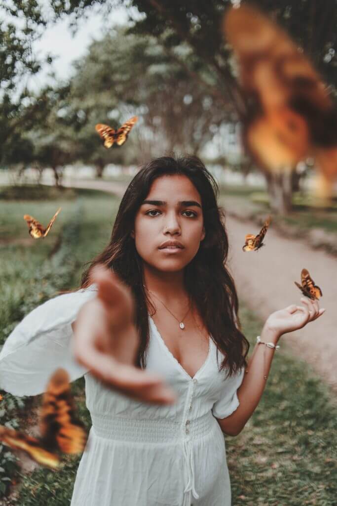 Transforming from being tired all the time and having side effects from MRI contrasts translated into girl with butterflies stretching out her hand towards the camera