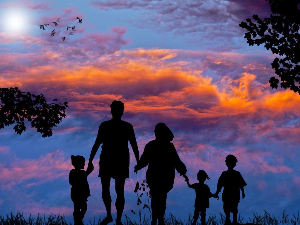 Family linking hands with beautiful sky to signify the importance of connection in nutrition and lifestyle coaching